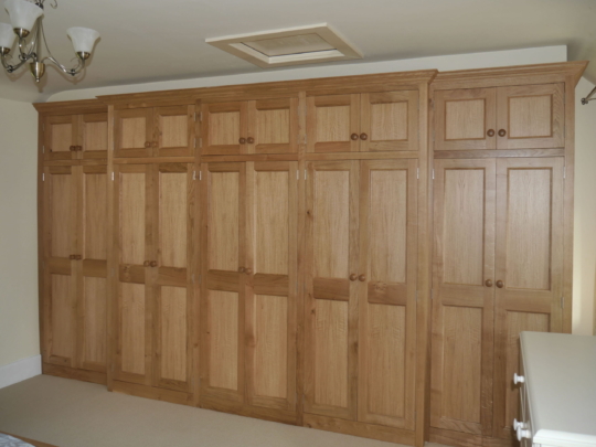 Large oak panelled breakfronted fitted wardrobe
